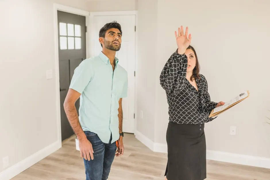 A real estate agent shows a house to a client, discussing the property details.